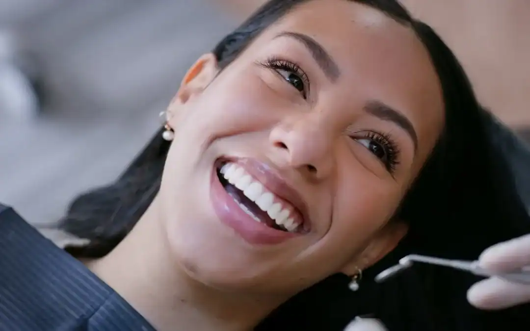 Smiling woman in dental chair receiving cosmetic dentistry treatment at Zen Dental in Enfield, CT.