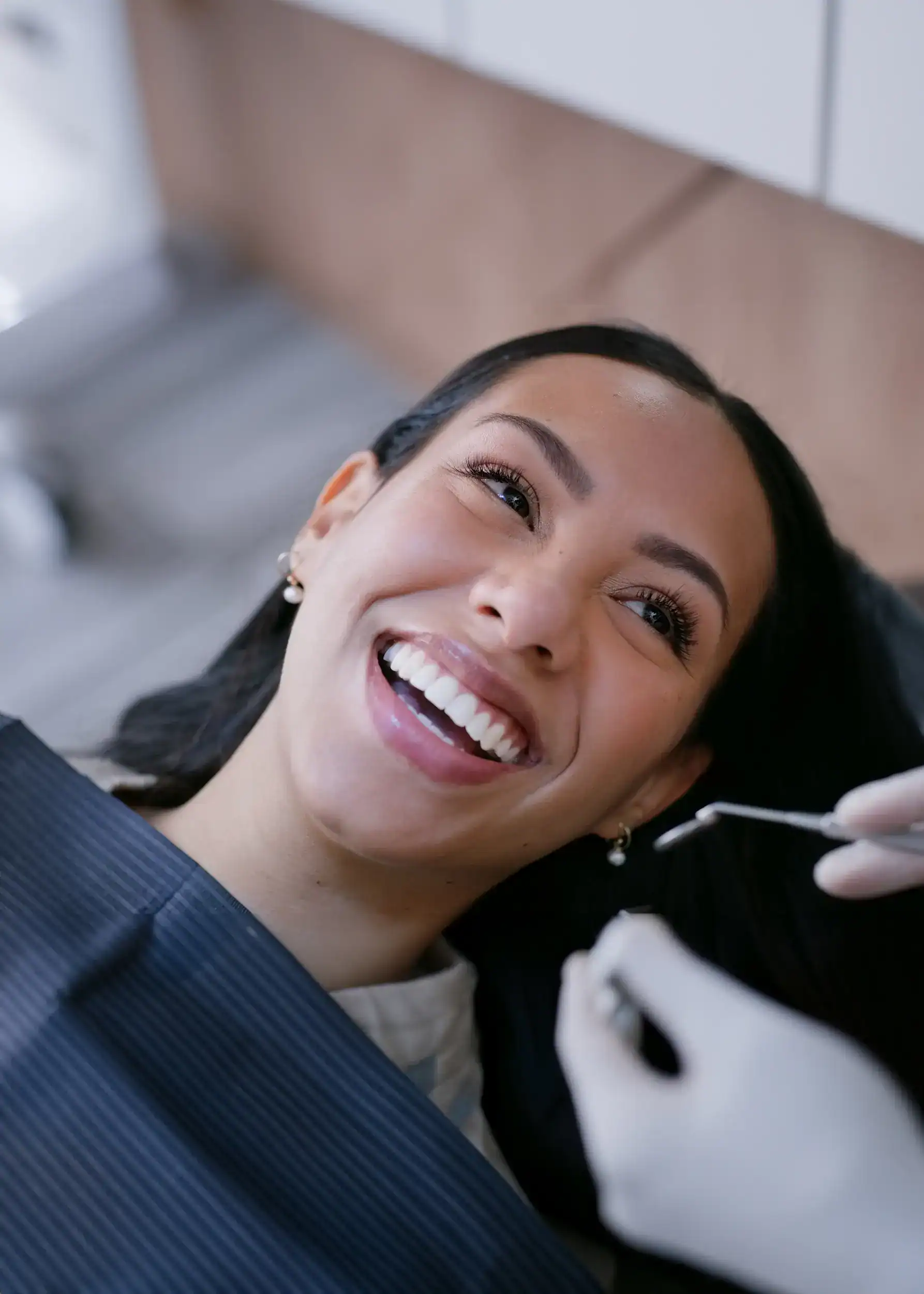 Smiling woman in dental chair receiving cosmetic dental treatment at Zen Dental in Enfield, CT.